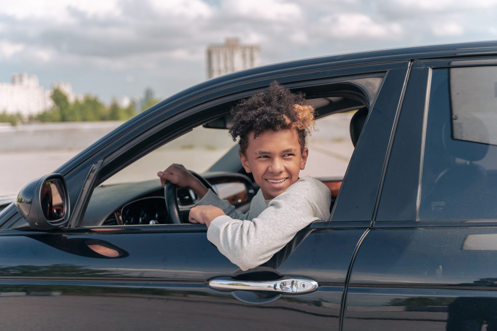 Smiling young driver sitting in a car